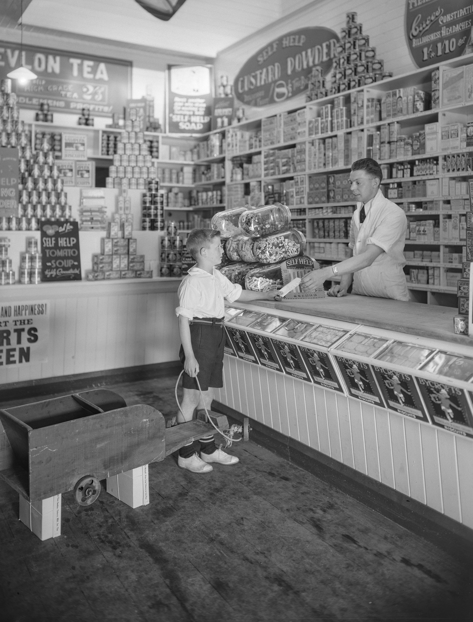 an old photo of a man and a boy in a store